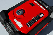 Red and black portable generator with visible branding on a gray background